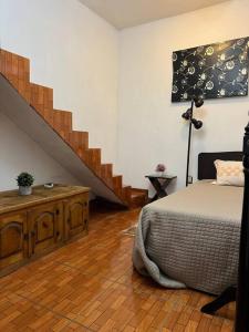 a bedroom with a bed and a staircase at Caza en zona residencial in Uruapan del Progreso