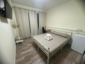 una piccola camera con letto e televisore di Park 20 Guest House ad Azzate