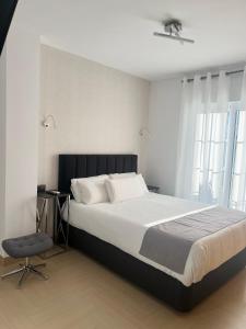 a bedroom with a large bed and a chair at Plaza de España Boutique Apartment in Nerja
