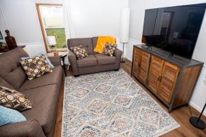 uma sala de estar com um sofá e uma televisão de ecrã plano em Home away from Home at Beyonder Getaway SH em Ankeny
