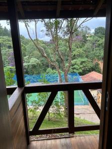 - une vue sur un arbre depuis la fenêtre dans l'établissement Chalé Ipê Rosa, à Pedra Azul