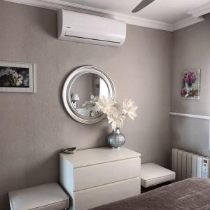 - une chambre avec un miroir et un vase fleuri dans l'établissement Primera Linea De Mar En Cambrils, à Cambrils