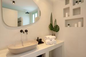 a bathroom with a sink and a mirror at Sugarwhite Suites with Private not Heated Pool in Emporio Santorini