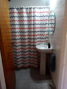 y baño con cortina de ducha y lavamanos. en Quinta El Cholito en Luján
