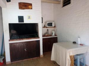 a kitchen with a table and a tv in a room at Quinta El Cholito in Luján