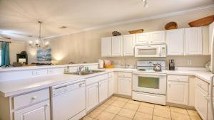 a kitchen with white cabinets and white appliances at 612 Willow Bend Condo in North Myrtle Beach