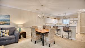 a kitchen and living room with a table and a couch at 612 Willow Bend Condo in North Myrtle Beach +18 photos