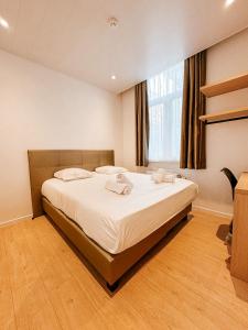 een slaapkamer met een bed met twee handdoeken erop bij Alpha Hotel in Oostende