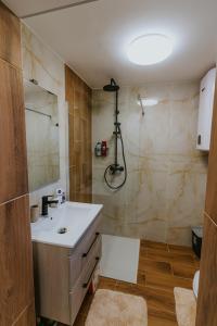 a bathroom with a sink and a shower at Ariel Pilismarót Vendégház in Pilismarót