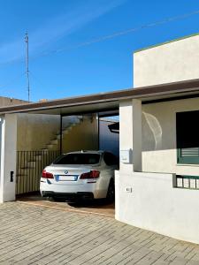 a white car is parked in a garage at Sunset Salentorelax San Gregorio in Marina San Gregorio