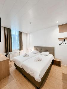 een slaapkamer met een groot wit bed in een kamer bij Alpha Hotel in Oostende