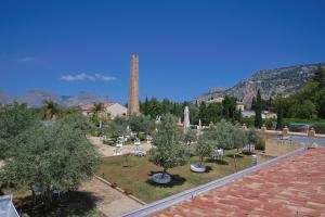 un cimetière avec des arbres et une tour en arrière-plan dans l'établissement Hotel Villa Lampedusa, à Palerme