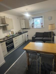 a kitchen and living room with a table and a couch at Stay Inn East West in Aberdeen