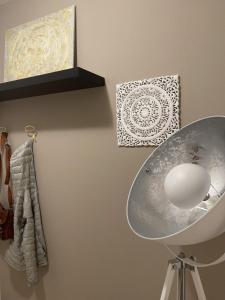 una lampada su un muro con un'immagine e un asciugamano di Appartamento Monte Irone a Ponte delle Arche