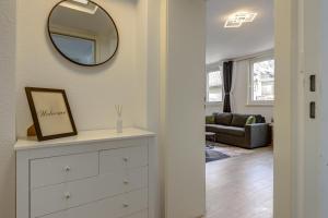 a room with a dresser and a mirror on a wall at K&M - Das Apartment - Zentral - Mit Arbeitsplatz in Wiesbaden