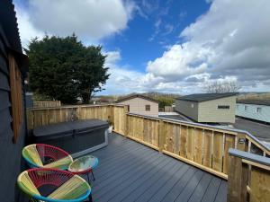 a deck with two chairs and a futon at Hafod Shepherd Hut in Aberystwyth