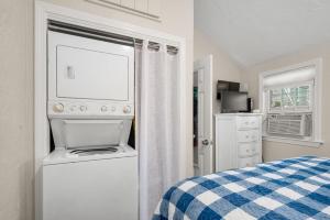 a bedroom with a washer and dryer next to a bed at 131 #7 North Shore Boulevard East Sandwich - Waters Edge 7 in East Sandwich