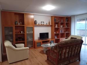 ein Wohnzimmer mit einem Sofa und einem TV in der Unterkunft La Bergerie de Lavernhe in Connac