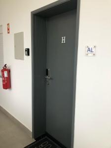 een zwarte deur met een bordje erop in een kamer bij Casa Papillon in Sagres