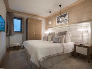 ein Schlafzimmer mit einem großen weißen Bett und einem Fenster in der Unterkunft Appartement de Charme à Courchevel Village - 4 pièces pour 7 personnes avec Garage - FR-1-575-26 in Courchevel