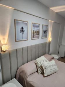 - une chambre dotée d'un lit avec un oreiller et des photos sur le mur dans l'établissement Amplio apartamento a cuadra del mar, cerca de todo, à Balneário Camboriú
