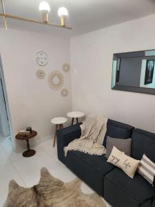 - un salon avec un canapé bleu et un tapis dans l'établissement Amplio apartamento a cuadra del mar, cerca de todo, à Balneário Camboriú