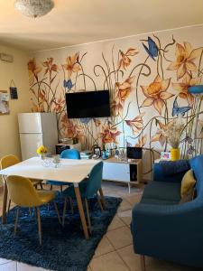 una sala de estar con una mesa y una pared con flores en The Loft E&E Blue Sky en Empoli