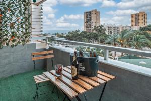 Una botella de vino sentada en una mesa en un balcón en Apartamento Brisa Playa, en Aguadulce