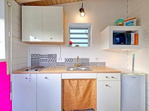 eine Küche mit weißen Schränken und einem Waschbecken in der Unterkunft Appartement Saint-Martin , 2 pièces, 3 personnes - FR-1-734-15 in Saint Martin