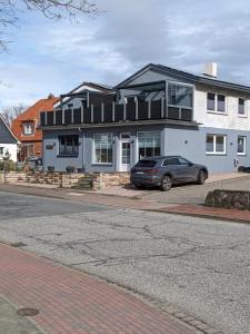 una casa con un coche aparcado delante en Ferienhaus Am Oland, en Büsum