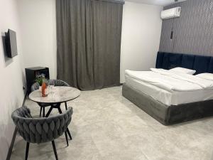 Schlafzimmer mit einem Bett, einem Tisch und Stühlen in der Unterkunft Lux Plaza (New Rooms) in Pʼarakʼar