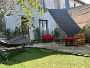 a patio with a hammock and a house at The house of little Paris in Montreuil