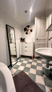 ein Bad mit einem Waschbecken und einem Spiegel in der Unterkunft The house of little Paris in Montreuil