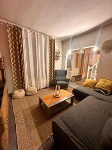 ein Wohnzimmer mit einem Sofa und einem Tisch in der Unterkunft The house of little Paris in Montreuil