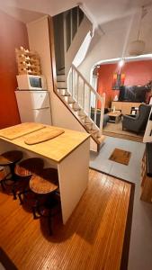 uma cozinha com uma mesa e cadeiras e uma escadaria em The house of little Paris em Montreuil