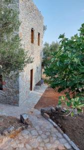 a stone building with a tree next to it at Casa Tsiliviani in Loukádhika