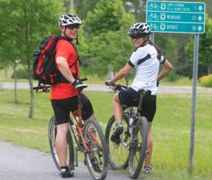 two people are riding bikes on a road at 23 Chemin des Skieurs in Stoneham