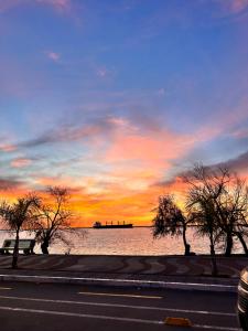 un coucher de soleil sur une étendue d'eau plantée d'arbres dans l'établissement Apart Pelusa, à Fray Bentos