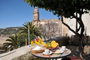 a tray of fruit on a table with a view of a building at Casa Sipione Papa in Modica