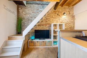 a living room with a tv under the stairs at L'alouette - Duplex Calme, Climatisé, Hyper-centre in Castres