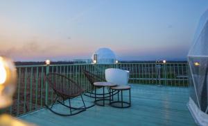 2 sillas y una mesa en una terraza con telescopio en Chateau Vartsikhe, en Varts'ikhe