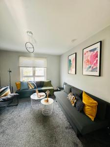 a living room with a couch and a table at Glasgow Modern style home , separate entrance in Knightswood