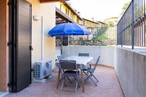 d'une table et de chaises avec un parasol bleu sur le balcon. dans l'établissement L&D home with pool, à Picedo