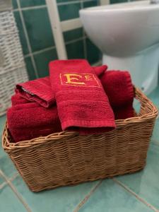 uma cesta cheia de toalhas vermelhas na casa de banho em The Loft E&E Blue Sky em Empoli