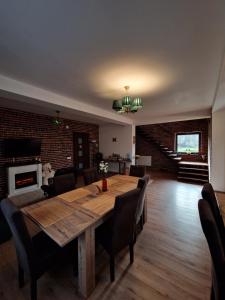 a dining room with a wooden table and chairs at Cabana din Pădure in Porumbacu de Sus