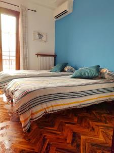 een groot bed met groene kussens op een houten vloer bij La casa di nonna Mary in Diano Castello
