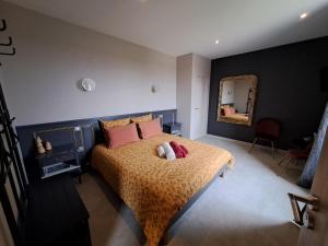 - une chambre avec un lit avec deux animaux rembourrés dans l'établissement La Pause Ô Logis, à Saint-Laurent-du-Jura