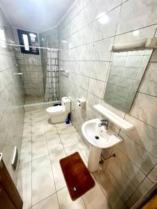 ein Bad mit einem Waschbecken und einem WC in der Unterkunft Hacienda Residence in Jaunde