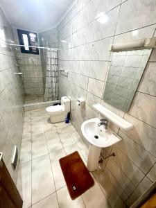 a bathroom with a sink and a toilet at Hacienda Residence - Solar Energized in Yaoundé +41 photos