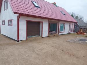 a garage with a red roof on a house at CozyStay in Otepää